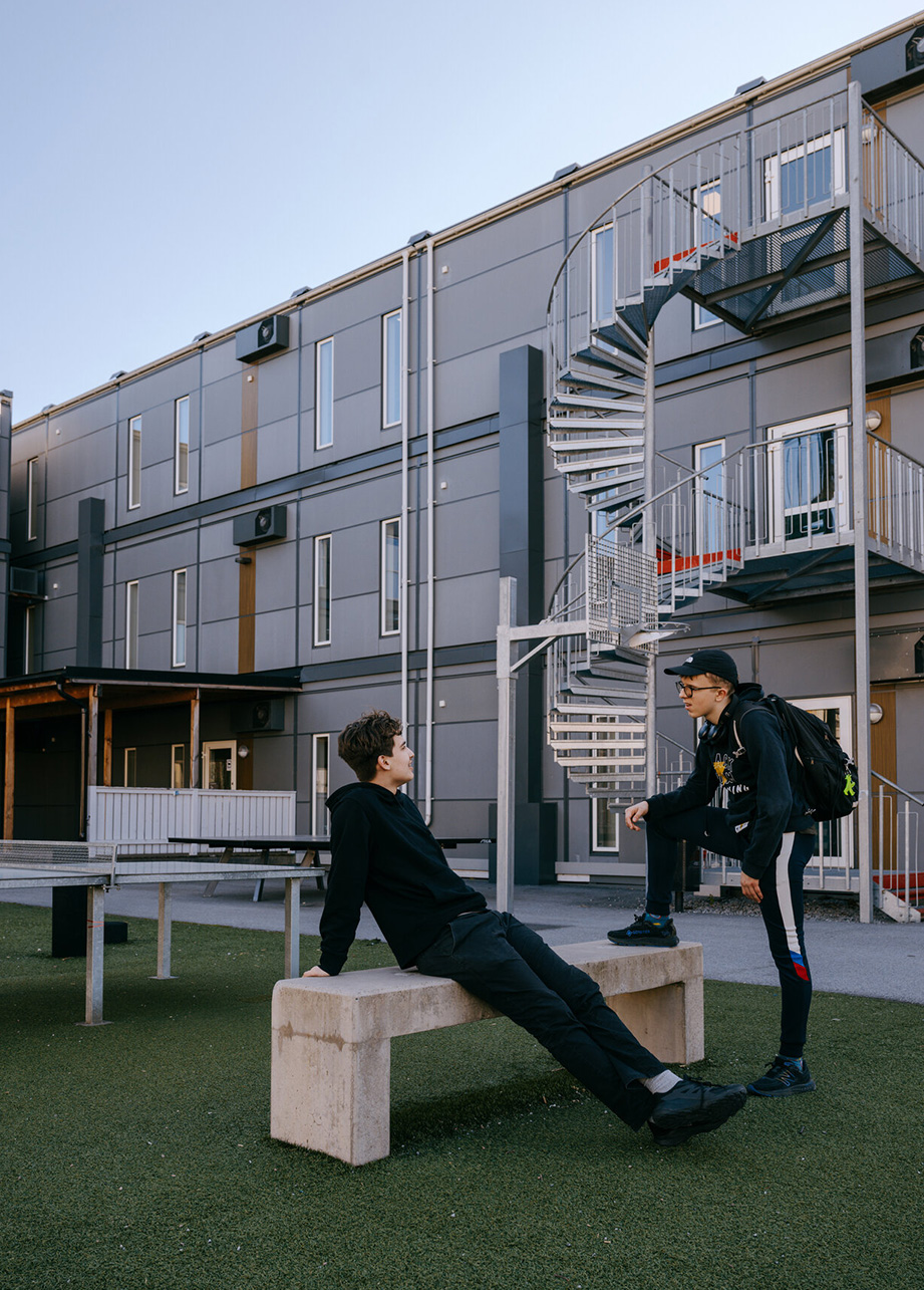 Elever samtalar utomhus på skolgården framför Expandias modullösning på Ekens skola i Hammarby Sjöstad.