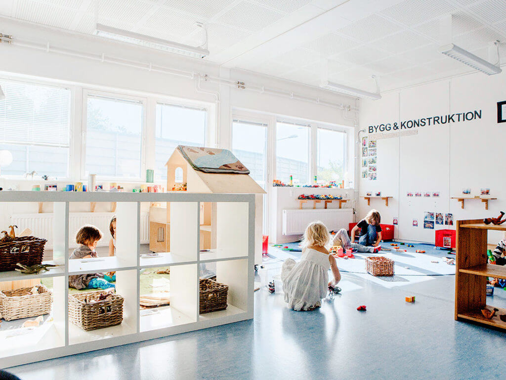 Barn som leker och bygger med material i en ljus och öppen inomhusmiljö i Expandias moduler