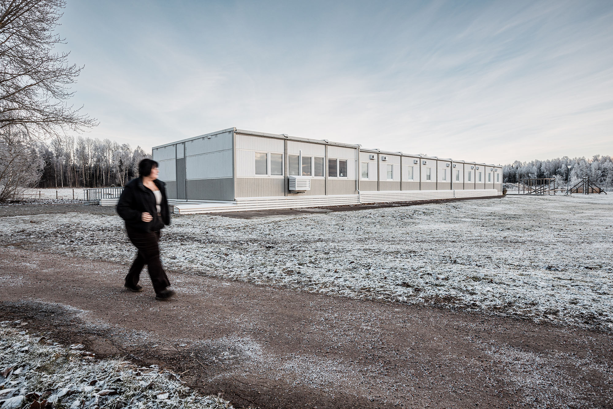 Boendemoduler placerade i öppen miljö vintertid, med gångväg i förgrunden.