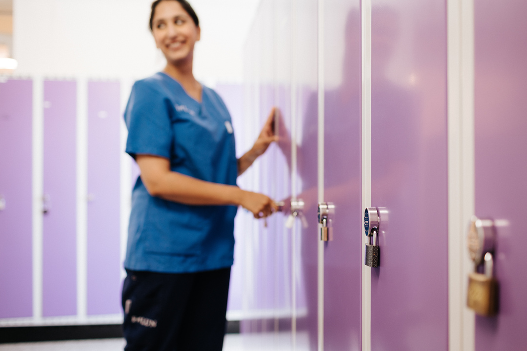 Omsorgspersonal öppnar ett skåp i ett omklädningsrum vid Herrhagsgården vård- och omsorgsboende i Falun.