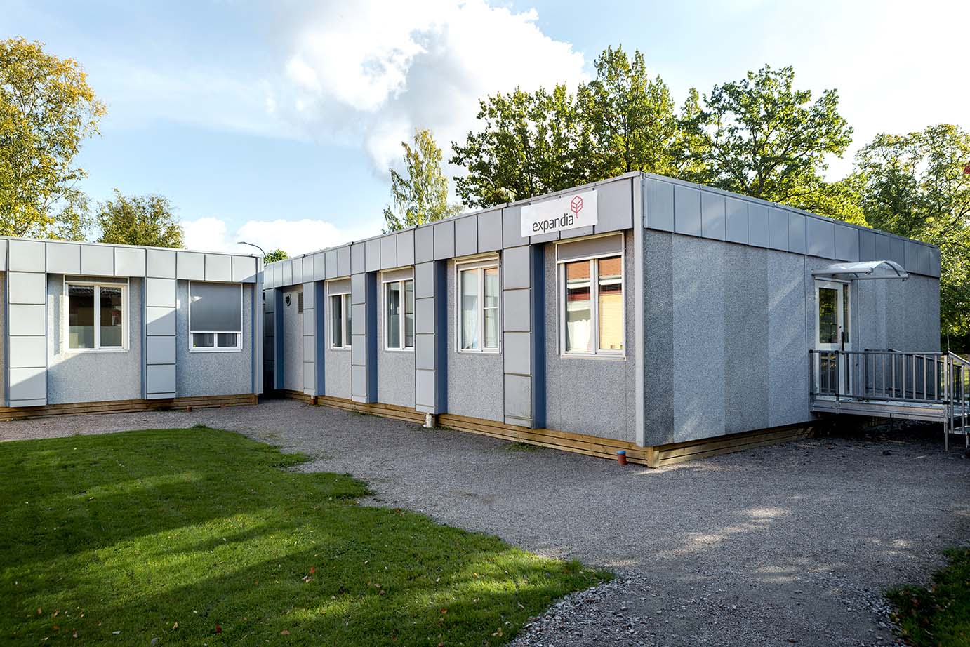 Exteriör av Skebäcks vårdcentral i Örebro, uppförd med moduler från Expandia. Entré med ramp och fönsterpartier omges av grönområde.
